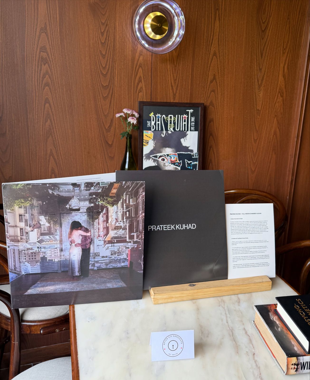 A Prateek Kuhad record and a framed print on a brunch table at Genre, Defence Colony